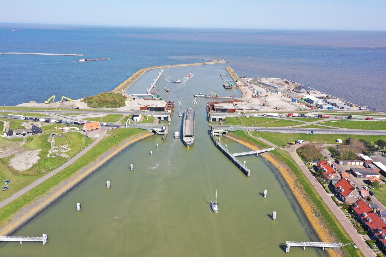 Dronefoto van het sluizencomplex Kornwerderzand met de bouwkuipen van de nieuwe keersluis